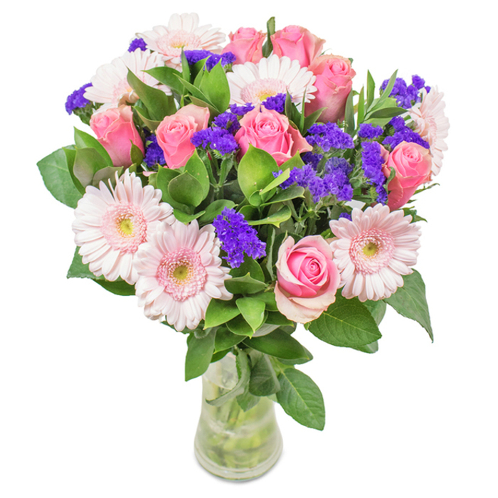 A vibrant floral arrangement symbolising Collier Row's spirit, this bouquet features an elegant mix of approximately seven to nine soft-to-medium pink roses, each showcasing signature spiral petals-some just beginning to unfurl, others gently opening. Nestled among them, around five to seven pale pink gerbera daisies display their signature radiating petals with near-white, luminous centers, bringing a fresh contrast. Rich purple statice clusters are artfully inserted throughout, providing texture and deeper colour that complements the pinks, while abundant green foliage enhances the bouquet's sense of lavishness and garden freshness-reflecting the greenery of Bedfords Park just a short drive away. The arrangement is presented in a sleek, clear glass vase with visible stems soaking in sparkling water, reflecting the clean, modern aesthetic of Collier Row Flowers. Designed as a joyous expression for birthdays, anniversaries, or as a beautiful accent for home or office decor near Romford, this bouquet conveys celebration, warmth, and sincere affection, embodying the thoughtful spirit of Collier Row's local florists.